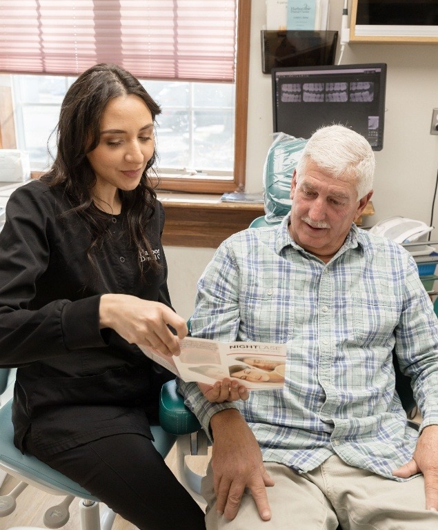 Dental team member showing a pamphlet to a patient